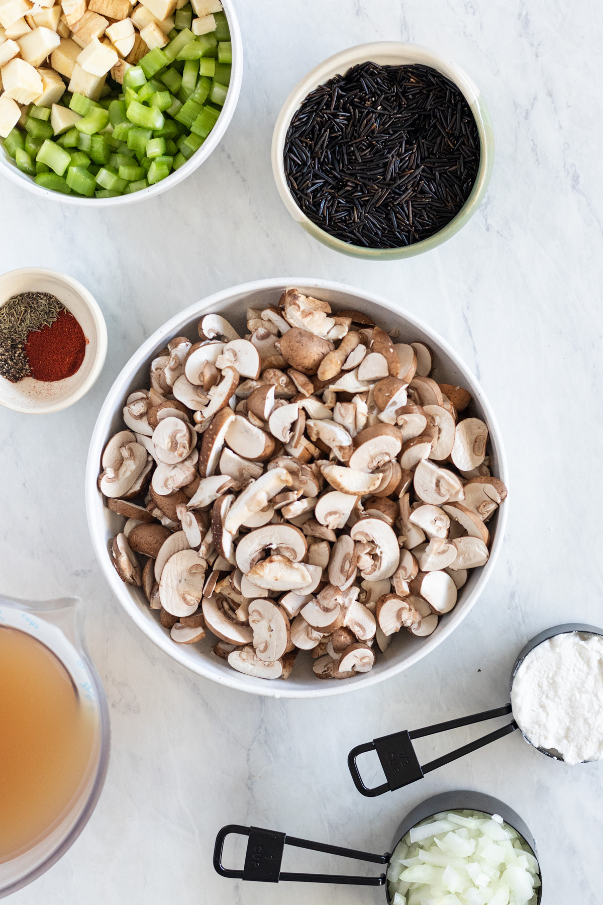Small bowls with mushrooms, rice, celery, onion and broth.