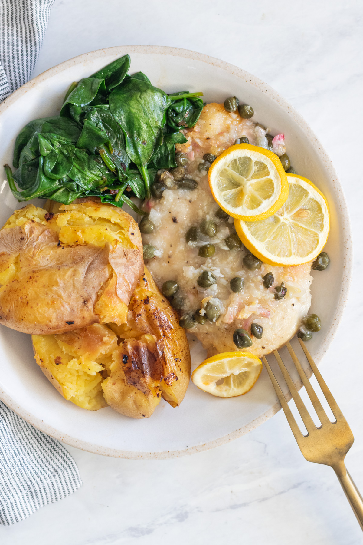 Chicken cutlet topped with lemon slices and capers.