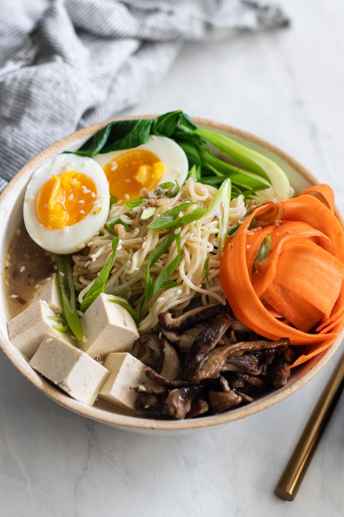 Gluten-free shiitake ginger ramen in a bowl near chopsticks.
